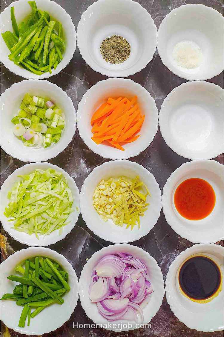 Photo of all the ingredients required to make chicken hakka noodles shown in white bowls arranged in matrix structure on table top