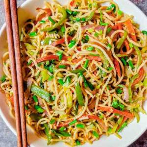 Thumbnail with top view photo of veg hakka noodles served in white dish along with red chopsticks, a recipe by homemakerjob