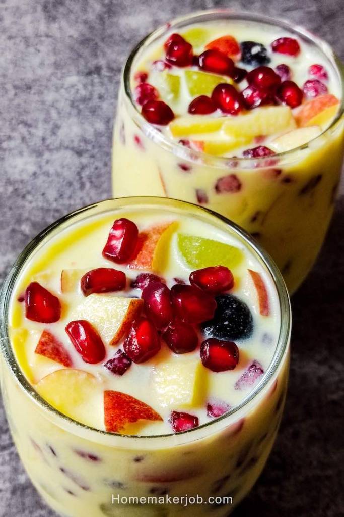 Tasty light yellow colored in a two glasses garnished with pomegranate seeds at top, put on a table, a recipe by homemakerjob.com