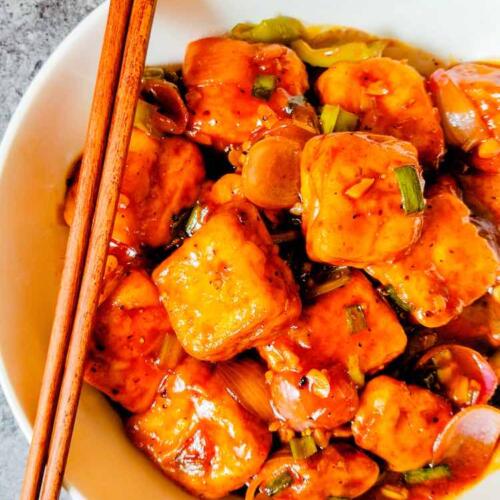 Chilli Paneer served in a white dish with two chopsticks kept on dish, by homemakerjob.com
