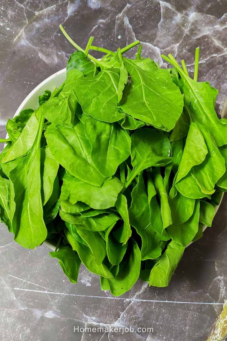 Nice fresh green spinach (palak) in white bowl on table as ingredient for palak chicken recipe