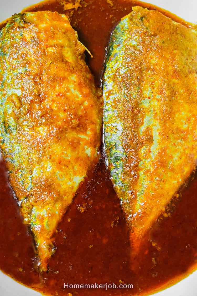 Top view close up photo of two fillets of bangda (ayala) fish in hot spicy red curry, served in a white dish by homemakerjob.com