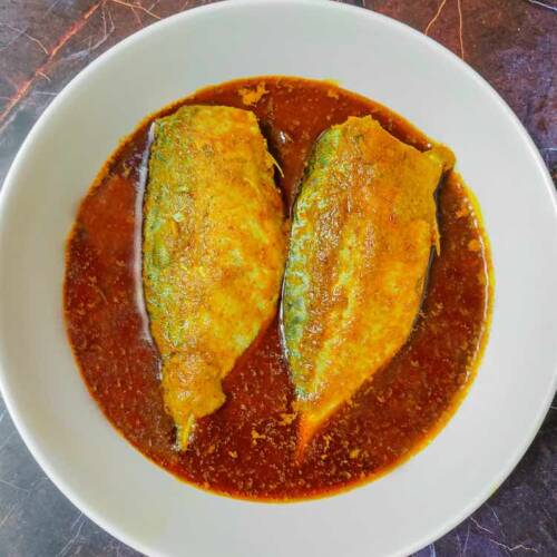 Two fillets of bangda (ayala) fish in hot spicy red curry, served in a white dish by homemakerjob.com