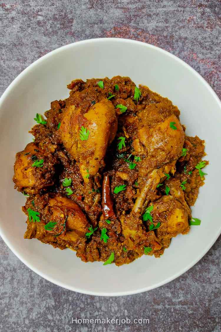 Ready hot spicy chicken bhuna masala served in a round white plate by homemakerjob.com