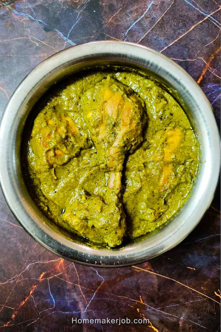 Ready hot Indian green (hariyali) chicken curry served in a white dish