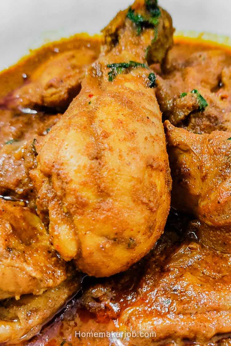 Close up photo of ready hot chettinad chicken gravy served in a white plate on a table by homemakerjob.com