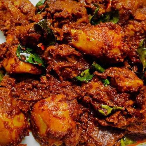 Close up photo of ready hot mangalorean chicken ghee roast served in a white dish by homemakerjob