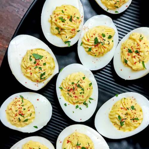 Close up photo of ready classic deviled eggs served in a triangular black plate by homemakerjob