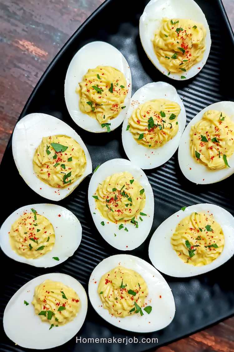 Close up photo of ready classic deviled eggs served in a triangular black plate by homemakerjob