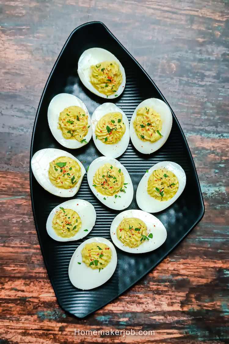 Photo of ready classic deviled eggs served in a triangular black plate by homemakerjob