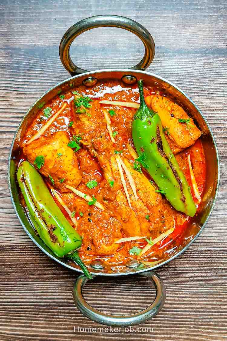 Achari chicken masala served with green bhavnagari chilies in a small kadai pot on a table top by homemakerjob.com