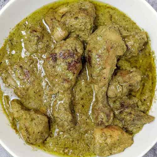 Close up photo of ready afghani chicken curry served in a big white bowl on a table top by homemakerjob.com