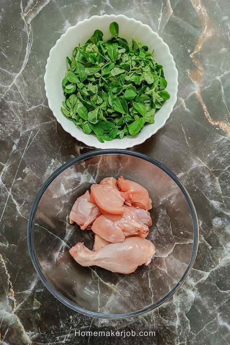 Fresh chicken and fresh fenugreek in bows as ingredients for chicken methi malai, kept on table top by homemakerjob.com