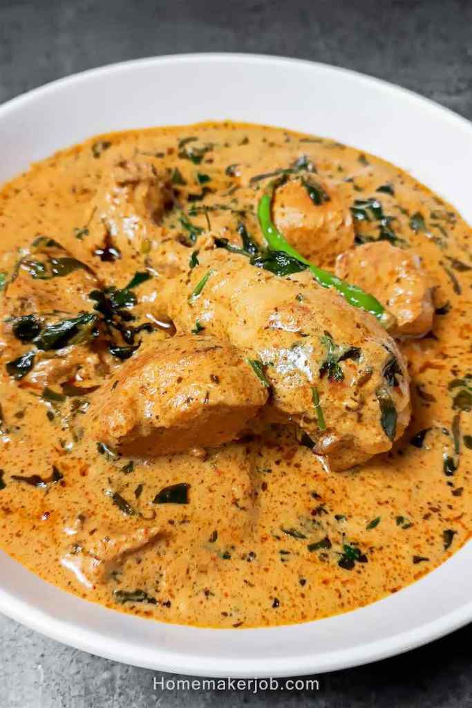 Close up photo of ready tasty methi malai chicken served hot in a white bowl on table top by Homemakerjob,