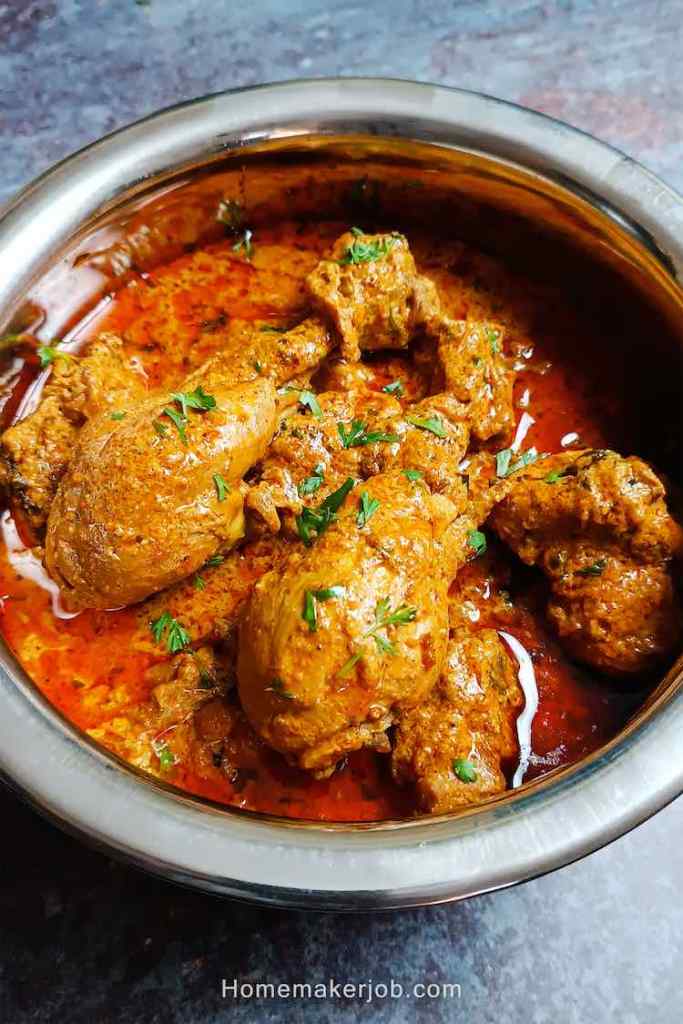 close up photo of chicken makhani handi masala served hot in a steel pot