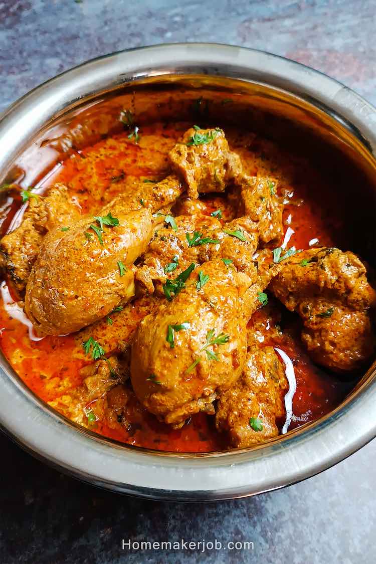 close up photo of chicken makhani handi masala served hot in a steel pot