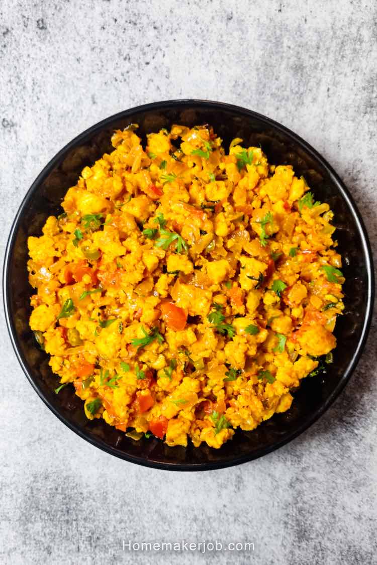 Ready hot restaurant style dry paneer bhurji served in a black plate on a table by homemakerjob