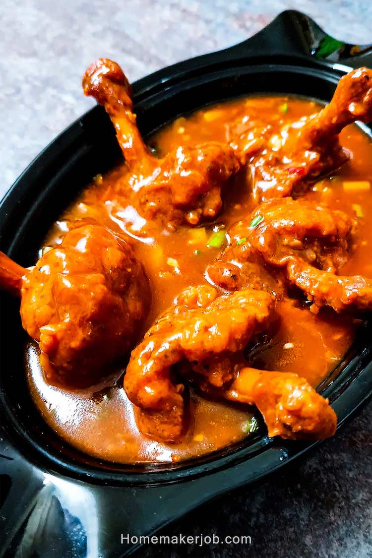 Close up photo of chicken lollipop gravy served hot in a white dish on a table top, by homemakerjob.com