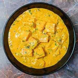 Top view photo of ready methi malai paneer served in a black bowl on a table, by homemakerjob.com