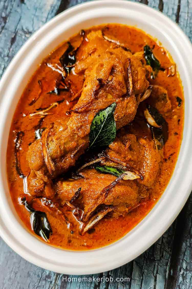 Top view close-up photo of nadan kerala chicken curry served hot in a white dish on a table by homemakerjob