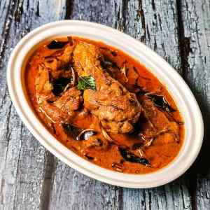 Top view photo of nadan kerala chicken curry served hot in a white dish on a table by homemakerjob
