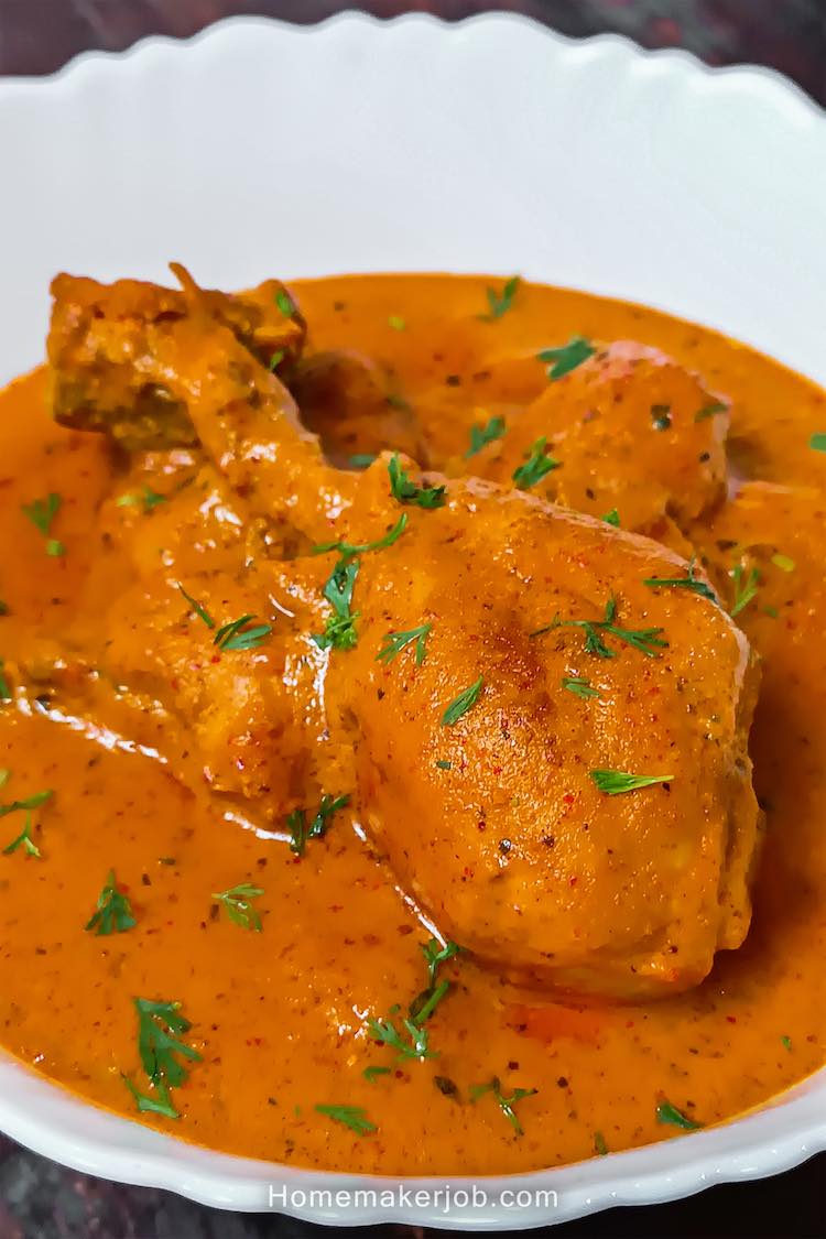 Close up photo of ready chicken lababdar served hot in a white bowl on a table top, by homemakerjob.com