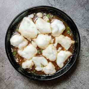 Top view photo of chinese chicken lung fung a.k.a. drgon phoenix soup served hot in a black bowl on a table; a recipe by homemakerjob.com