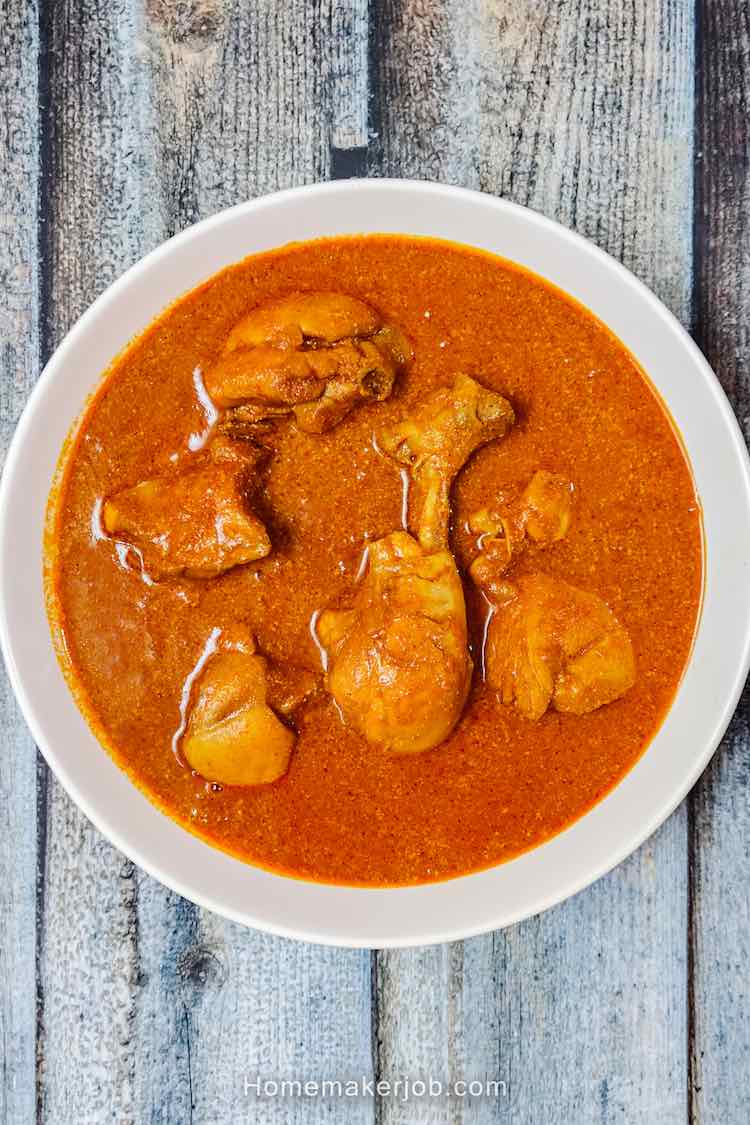 Top view photo of authentic goan chicken curry recipe served hot in a white bowl on a table, by homemakerjob.com