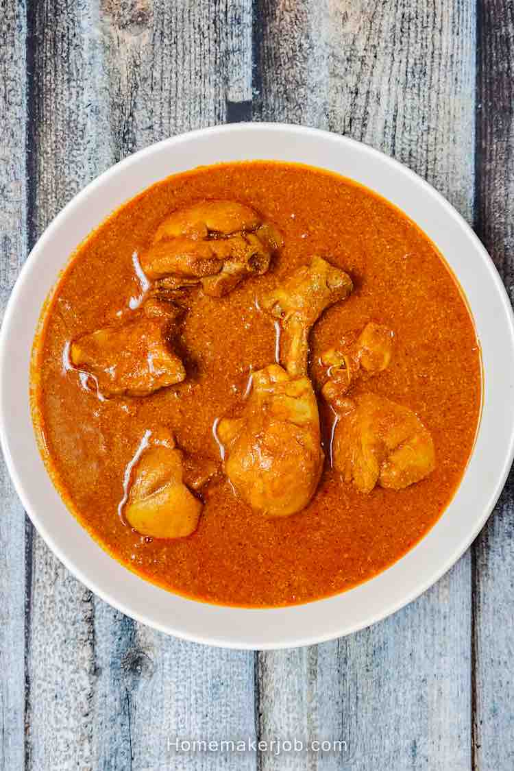 Top view photo of traditional goan chicken curry recipe served hot in a white bowl on a table, by homemakerjob.com