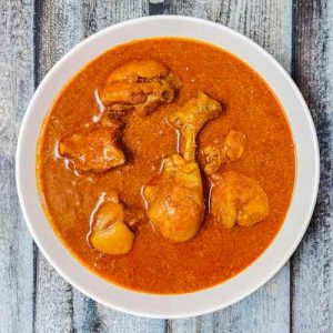 Top view photo of authentic goan chicken curry recipe served hot in a white bowl on a table, by homemakerjob.com
