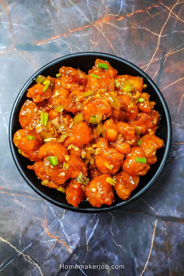 Dry gobi (cauliflower) manchurian served hot in a black bowl by homemakerjob.com