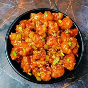 Dry gobhi (cauliflower) manchurian served hot in a black bowl by homemakerjob.com