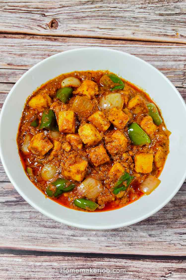 Top view photo of restaurant style kadai paneer served hot in a white bowl on a table, a recipe by homemakerjob.com