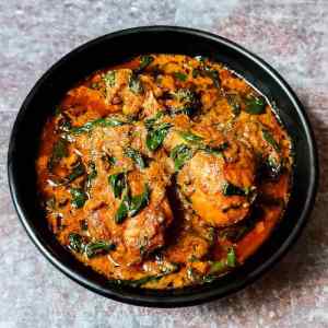 Fenugreek chicken gravy served hot in a black bowl on a table by homemakerjob