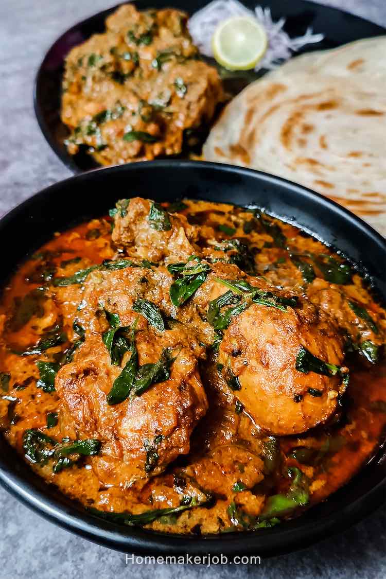 Methi murgh masala served hot in a black bowl on a table by homemakerjob