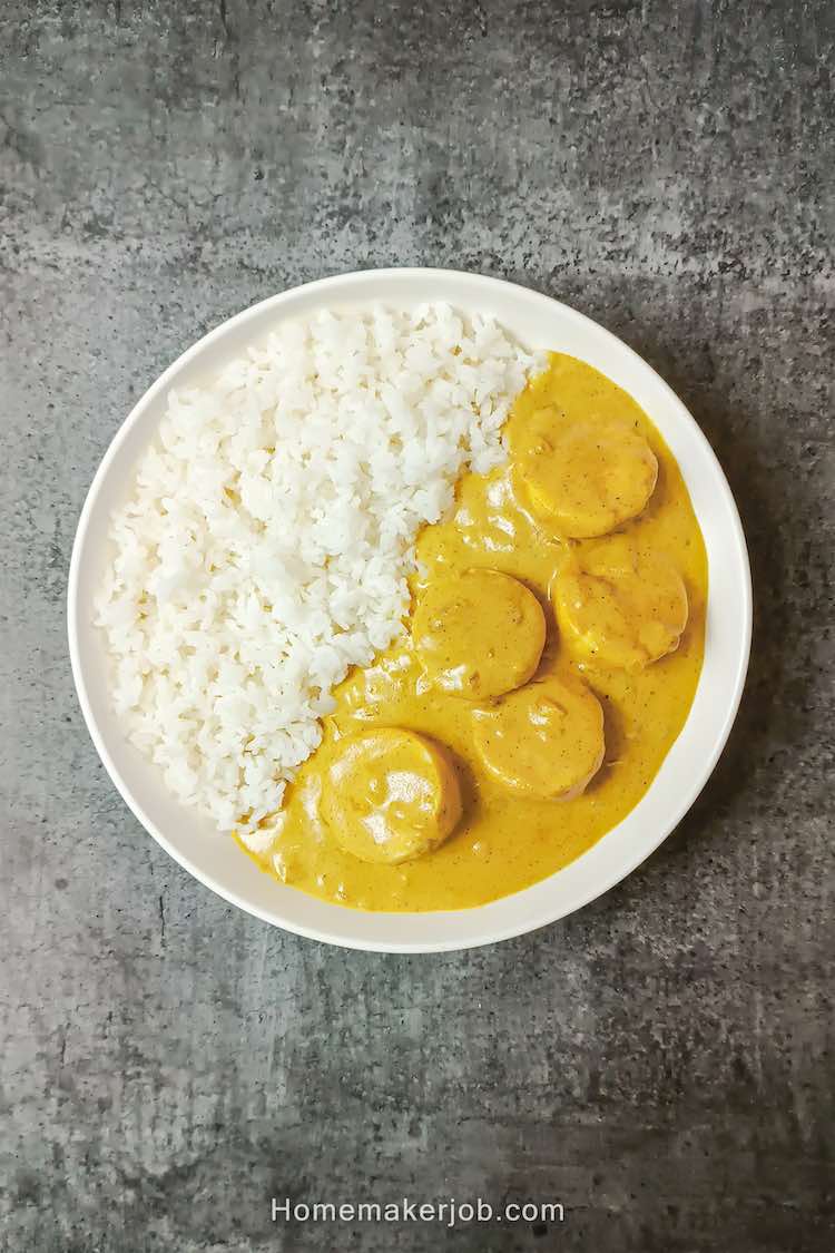 Top view photo of old fashioned curried eggs served along with white rice in white bowl on a table by homemakerjob.com