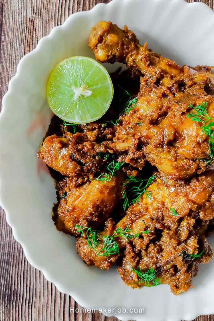 Close-up photo of ready spicy hot chicken sukka curry dry served in white dish garnished with a lemon slice by homemakerjob.com