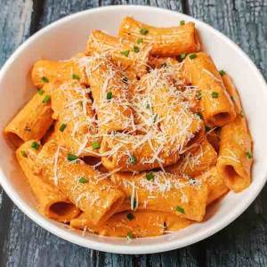 Top view of Gochujang Pasta in a white bowl, garnished with grated cheese on top of pasta, a recipe by homemakerjob.com