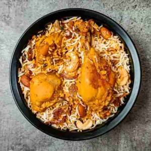 Top view photo of chicken mughlai biryani in a black bowl on a table, a recipe by homemakerjob.com